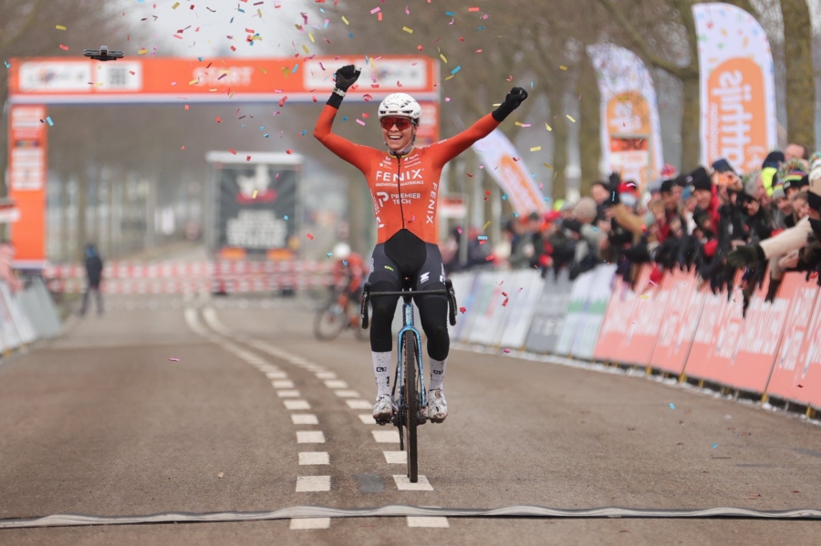 Ceylin del Carmen Alvarado winning the 2026 Netherlands Cyclocross National Championship, crossing the line in a snow of confetti, arms raised smiling with joy.